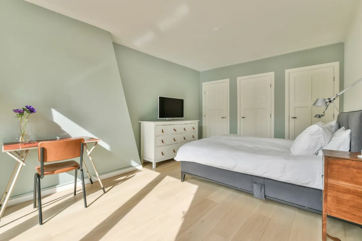 Bright bedroom with pale sage green walls