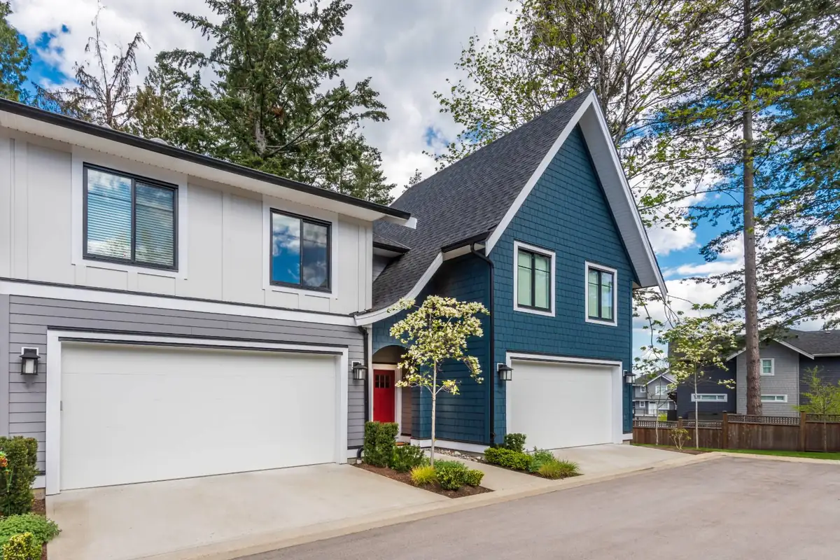 Two storey homes with white board and batten siding, dark blue shingle siding and white trim